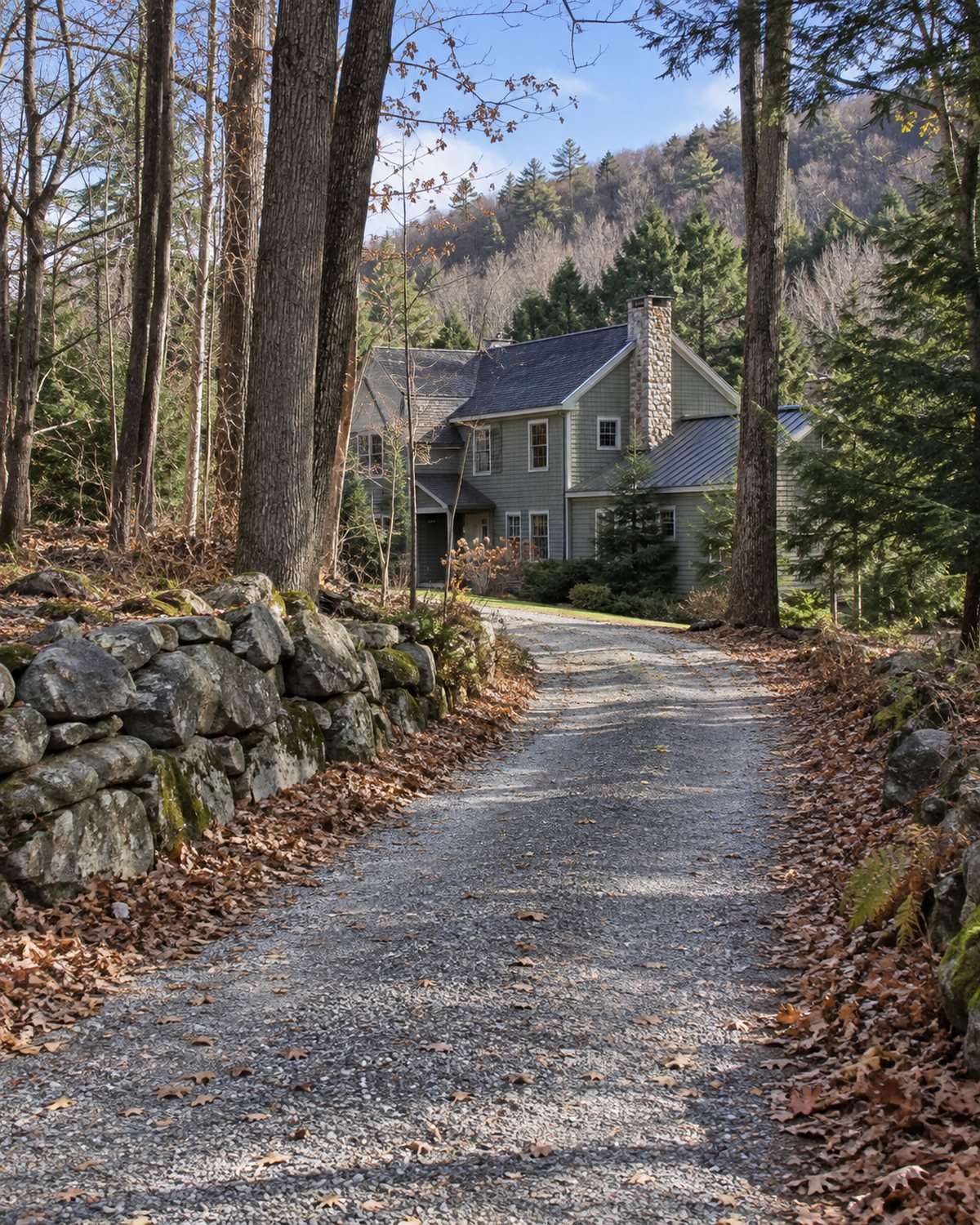 Wooded Norwich home with a gravel approach and Upper Valley hills beyond